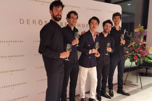 Four men around Haiou Zhang holding a glass of champagne