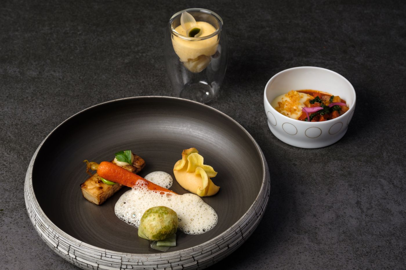 three attractive prepared dishes on a grey table in a 5 star hotel in the black forest